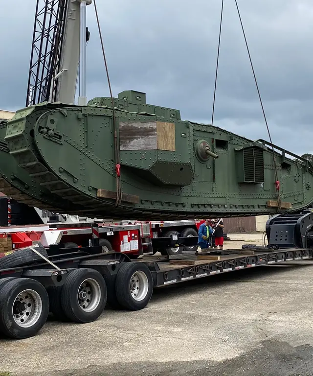 Military vehicle strapped to a lowboy trailer